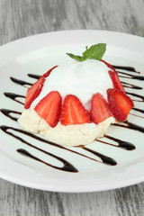 Tasty meringue cake with berries on wooden table