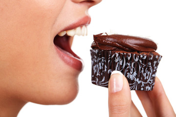 Closeup of woman eating chocolate cupcake