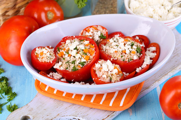 Stuffed tomatoes in bowl on wooden table close-up