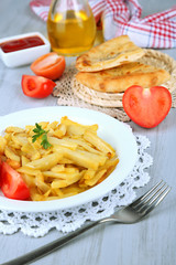 Fried potatoes on plate on wooden table close-up