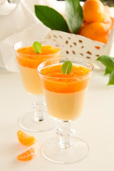 orange panna cotta with slices of oranges.