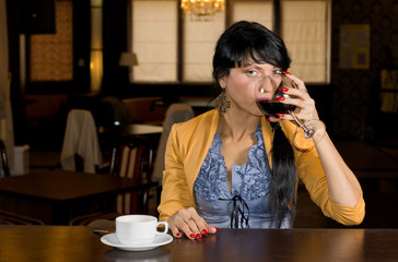 Woman drinking wine and coffee at a bar counter