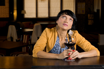 Thoughtful woman sitting at the bar