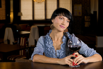 Lonely young woman drinking alone