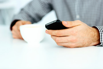 Closeup image of a male hand typing on smartphone