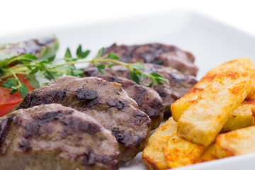 Roasted meatball with french fries on the side close-up