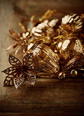 Golden christmas ornaments on wooden background