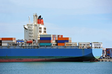Container stack and ship under crane bridge