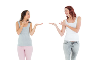 Two happy young female friends holding out their hands