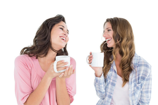 Cheerful friends chatting while drinking coffee