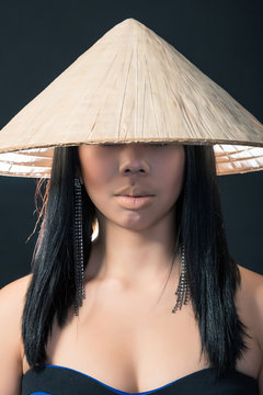 Beautiful brunette Asian woman with long black hair wears vietna