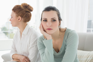 Unhappy friends not talking after argument on the couch