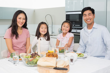 Happy family of four enjoying healthy meal in kitchen
