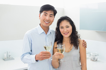 Loving young couple with wine glasses in kitchen