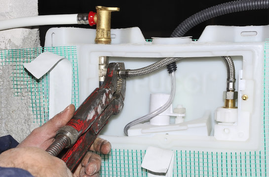 Worker assembles a manifold water system with focus on hands