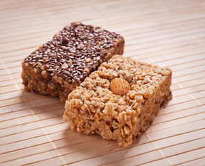 Homemade flapjack with almonds and seed on wooden mat.
