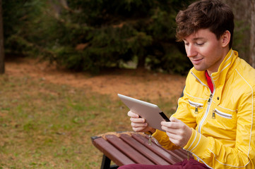 Fototapeta premium Man with tablet sits in the Park