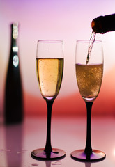 Pouring two Champagne toast cups