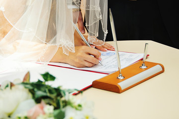 Bride signing marriage license or wedding contract