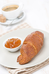 fresh croissant with jam and coffee