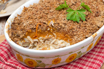 Gratin with fish and pumpkin in a ceramic form, close-up