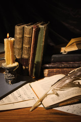 Old books and candles on wooden table