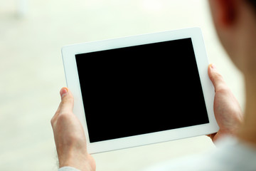 Closeup image of male hands showing screen of tablet computer