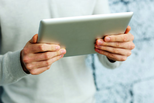 Closeup image of male hands holding tablet computer 