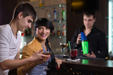 Laughing couple drinking at a pub counter