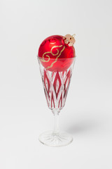 Champagne glass with red accents and Christmas ball- isolated