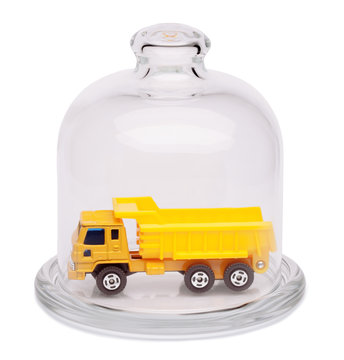 Toy dump truck in a glass dome.