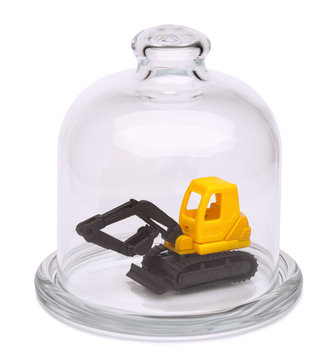 Toy yellow excavator in a glass dome