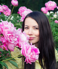 Young woman with pink peonies