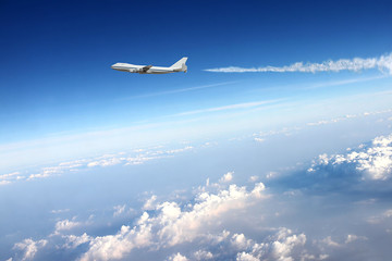 Naklejka na ściany i meble Airplane in clouds background.