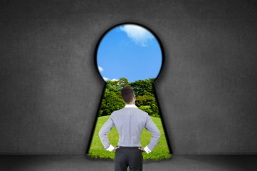 Obraz premium Silhouette of businessman against black wall with key hole