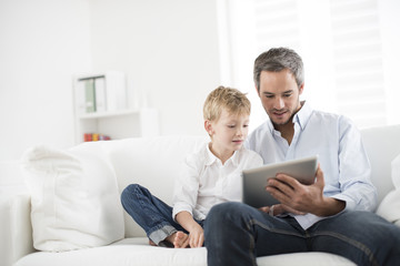 father and son playing on a tablet