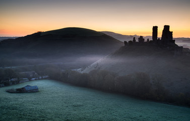 Obraz premium Medieval castle ruins with foggy landscape at sunrise