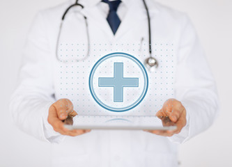 male doctor with stethoscope holding tablet pc