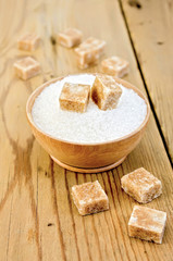 Sugar brown and white in a wooden bowl on a board