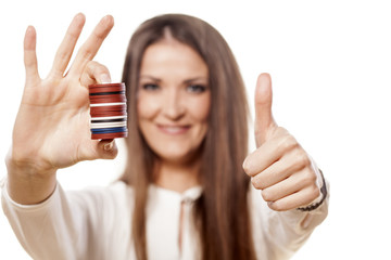 woman holding a pile of chips in her hands and showing thumbs up