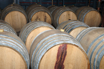 Wine barrels in arrangement waiting in a cellar