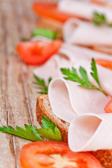 bread with sliced ham, fresh tomatoes and parsley