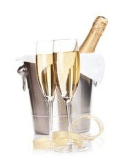 Champagne bottle in ice bucket, two glasses and christmas decor