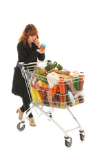 Woman with full shopping cart reading label