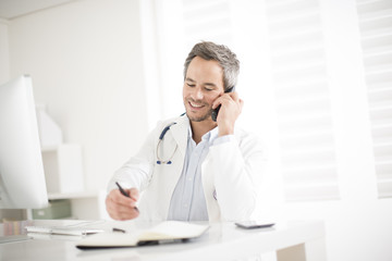 young doctor on phone at his office