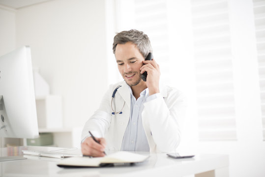 Young Doctor On Phone At His Office