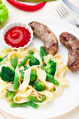 Fettuccine with vegetables and fried sausages