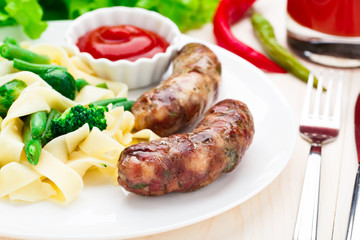 Fettuccine with vegetables and fried sausages