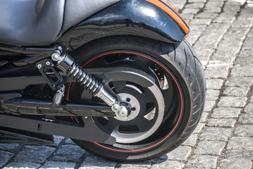 Rear wheel of the powerful motorcycle on street background