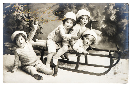 old photo of kids with sledge. vintage christmas postcard